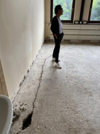 Ein tiefer Riss zieht sich einmal komplett ringsum an der Wand durch den Boden dieses Klassenzimmers. Helga Raab-Wasse, Mitglied im Bauausschuss, betrachtet den Zustand mit Sorge. (Foto: Sabine Balleier)